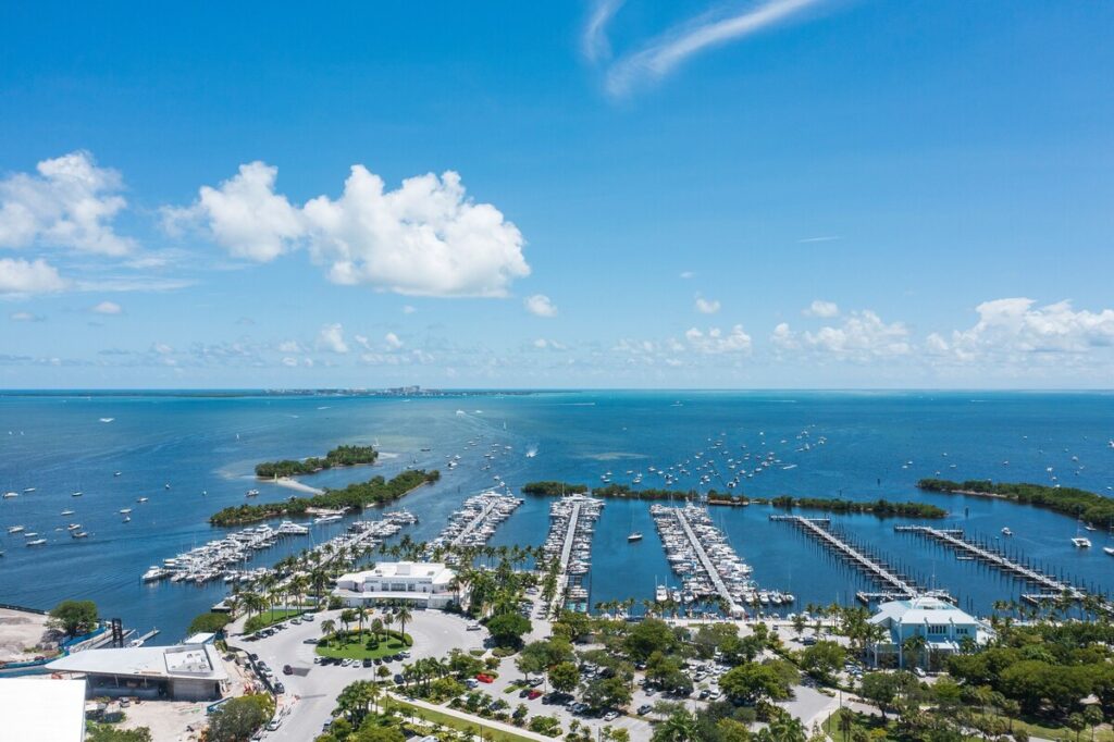 A breathtaking aerial view of a marina in Miami, showcasing the stunning blue waters and vibrant coastal lifestyle that attracts many New Yorkers to relocate to Florida.
